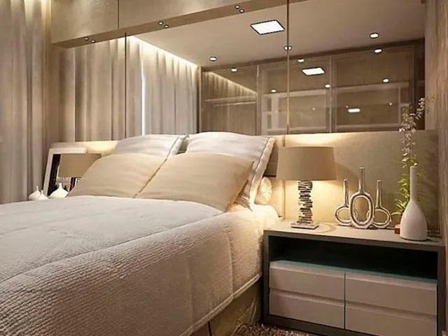 Espelho na cabeceira de cama em quarto de casal