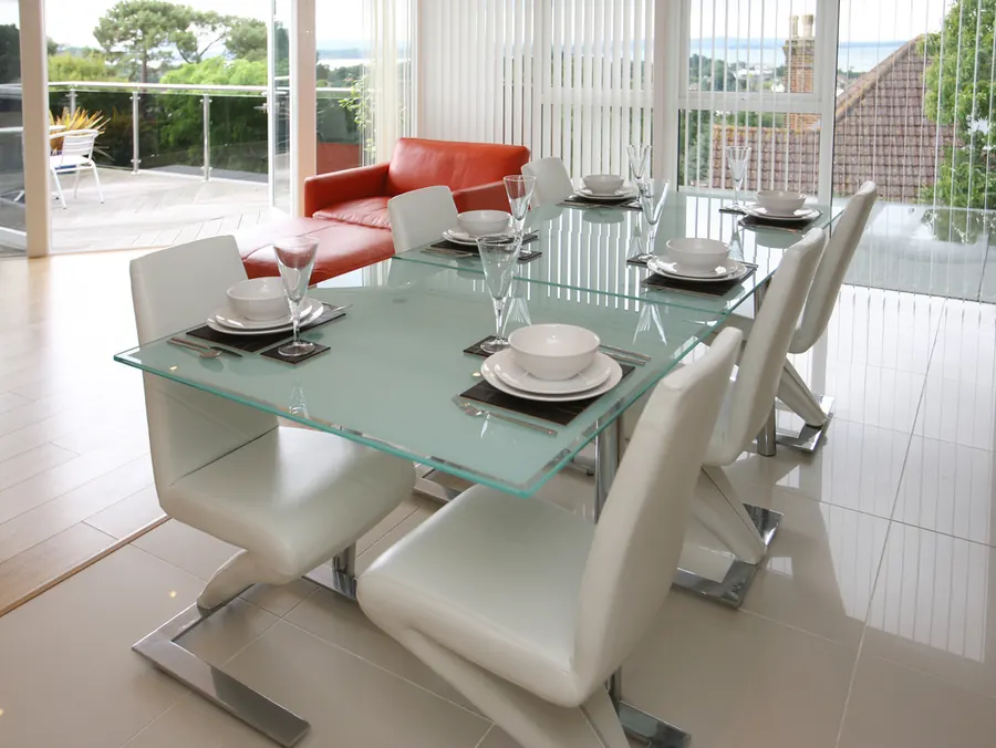 Mesa de jantar com tampo de vidro retangular e cadeiras modernas